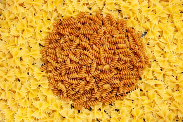 Free photo top view little raw pasta on dark background