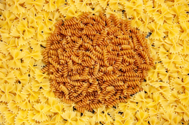 Top view little raw pasta on dark background