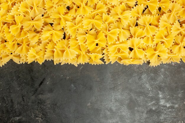 Top view little raw pasta on dark-grey background