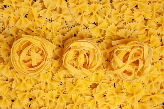 Foto gratuita vista dall'alto piccola pasta cruda cibo pasto colore foto pasta italiana molti
