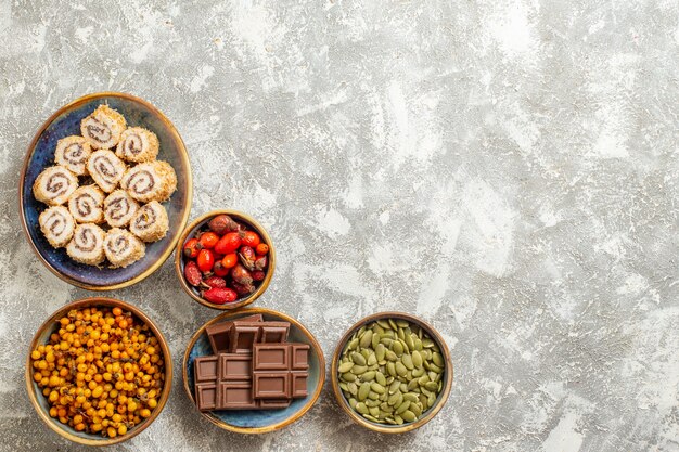 Top view little roll candies with chocolate on white background