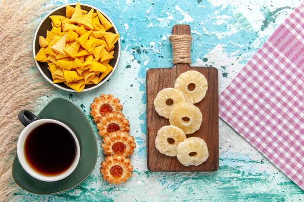 Top view little spicy chips with salted crackers and cookies on light blue surface cookie biscuit sweet sugar tea tea