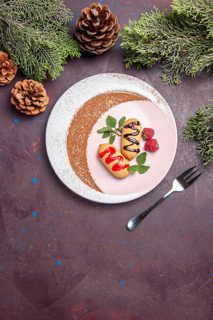 Top view of little sweet biscuits inside designed plate on black