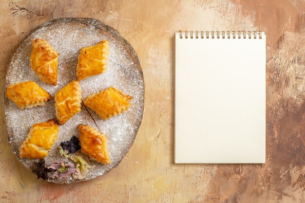 Top view of little sweet pastries for tea on a light background