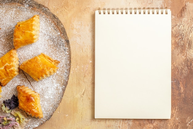 Top view of little sweet pastries for tea on light background