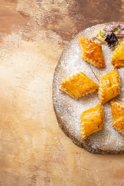 Top view of little sweet pastries for tea on light background