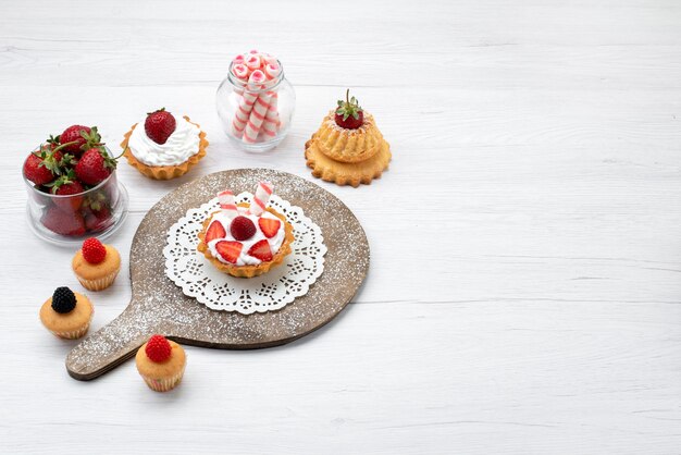 Top view little yummy cake with cream and sliced strawberries cakes on the white background cake berry sweet bake fruit bake