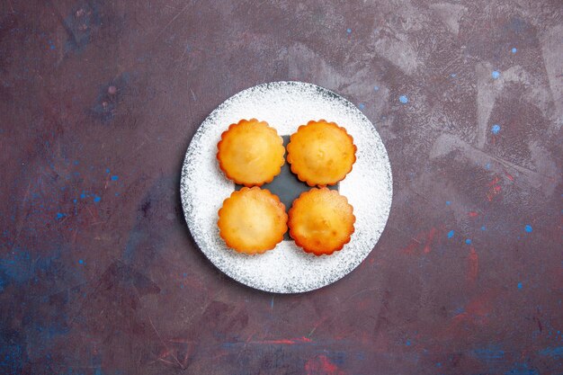 Top view little yummy cakes inside plate on a dark surface sweet pie biscuit cookie tea cake