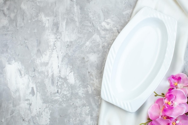 Top view long elegant plate with pink flowers on white surface picture horizontal feminine glass colour beauty