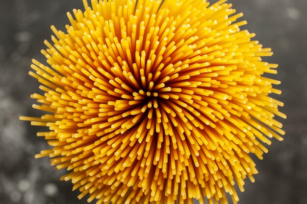 Top view long italian pasta raw on a dark-grey background