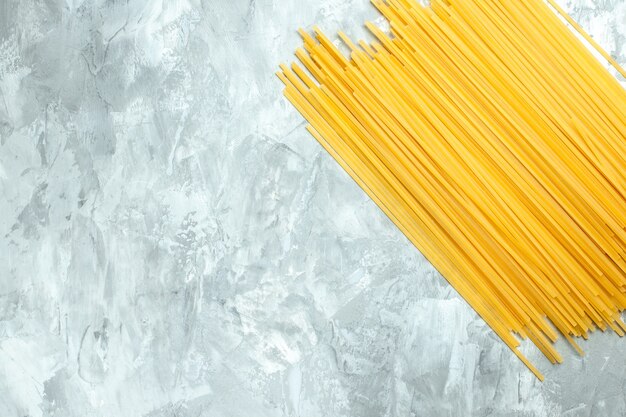 Top view long italian pasta raw product on white background