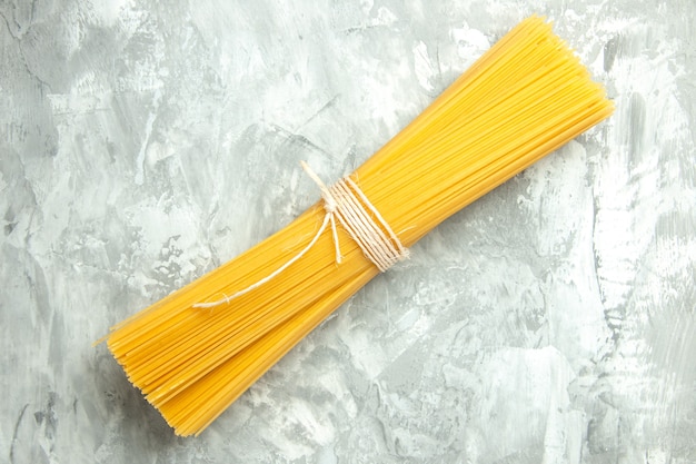 Top view long italian pasta raw tied on light background