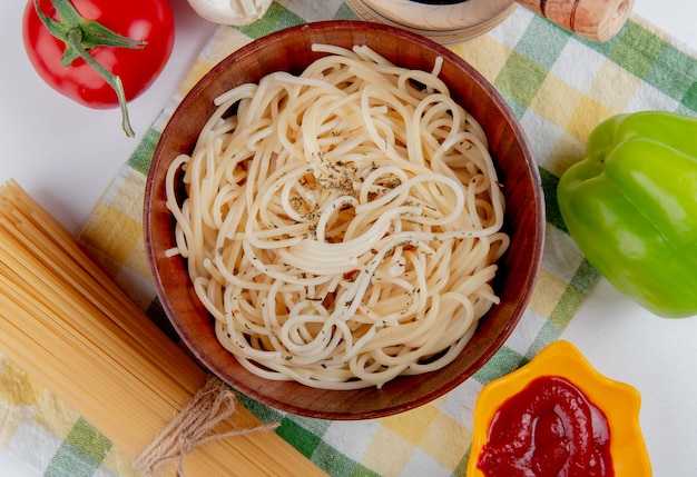 격자 무늬 천으로 화이트 토마토 검은 후추 케첩 마늘 고추와 당면 그릇에 마 카로 니 파스타의 상위 뷰