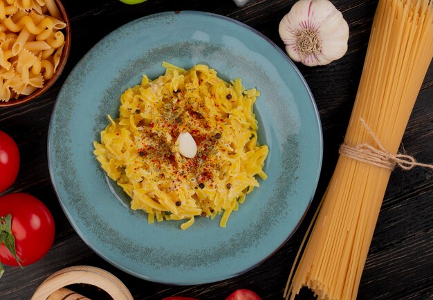 Top view of macaroni pasta in plate with tomatoes