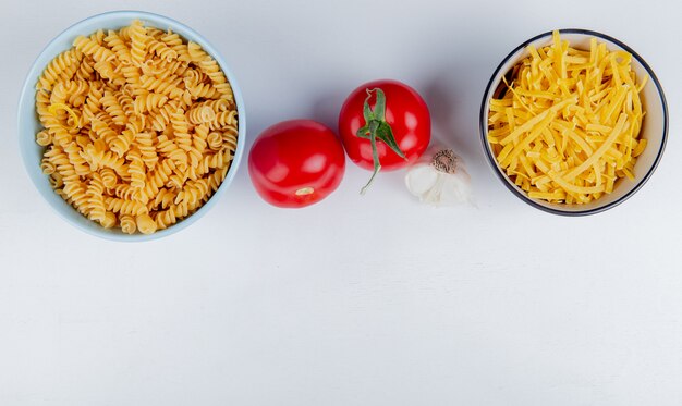 복사 공간 흰색에 토마토와 마늘 rotini 및 tagliatelle로 마카로니의 상위 뷰