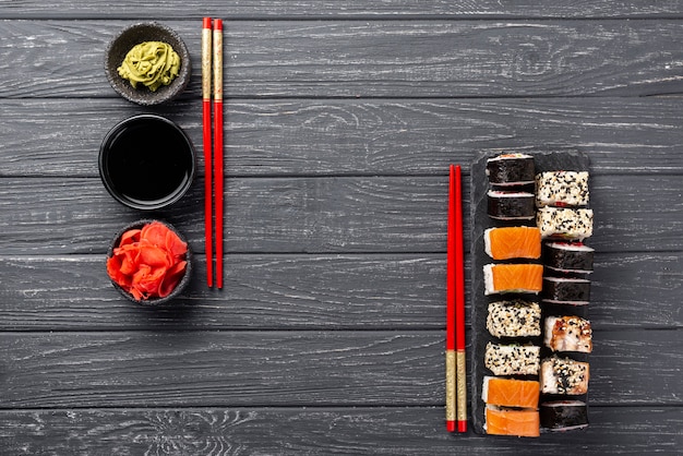 Top view maki sushi assortment on slate with chopsticks