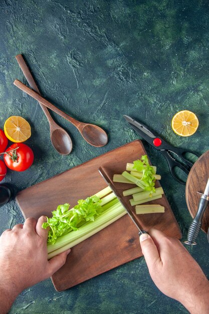 Top view male cook cutting celery on a dark table salad diet meal color photo food health