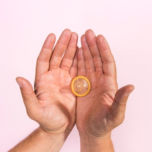 Top view man holding a transparent condom