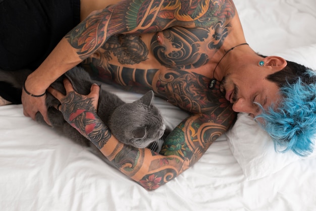 Free photo top view man laying in bed with cat