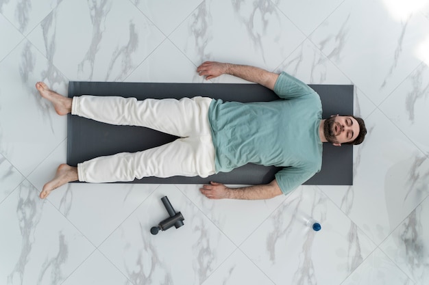 Top view man laying on yoga mat