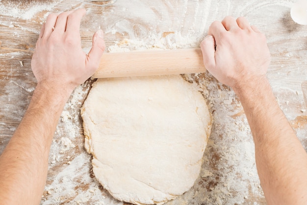 Foto gratuita vista dall'alto dell'uomo che produce la pasta per la pizza