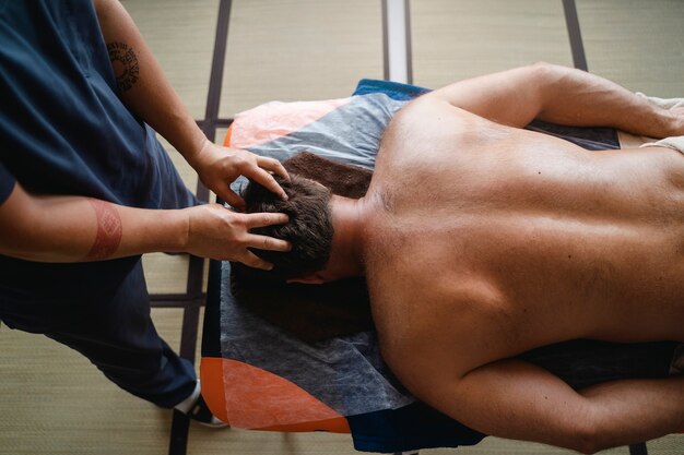 Free photo top view man massaging patient