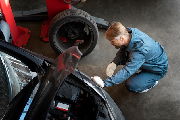 Free photo top view man repairing car