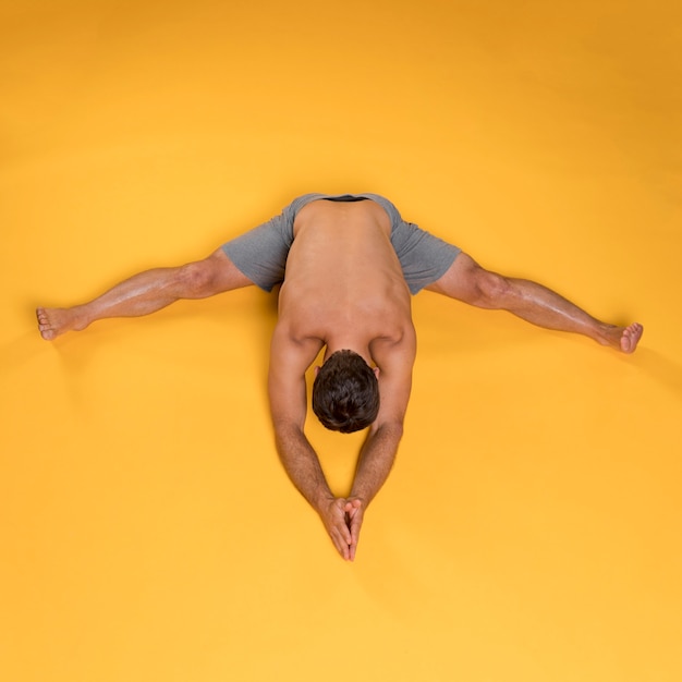 Free photo top view man seated forward bend pose