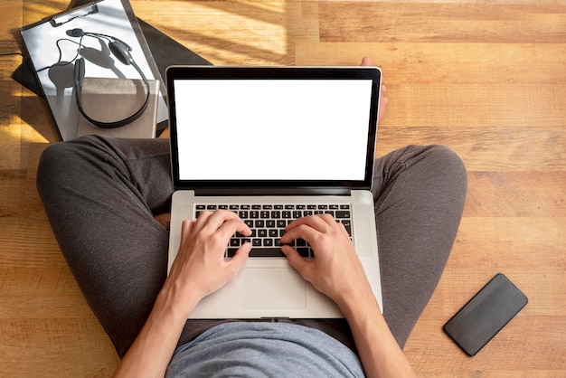 Top view of man using laptop at home in quarantine to work