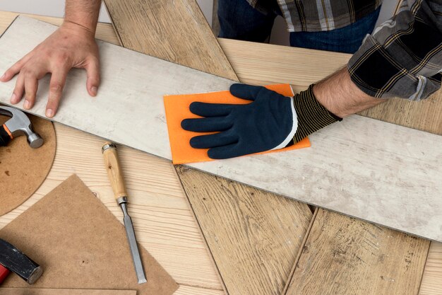 Top view man using sand paper carpentry workshop concept