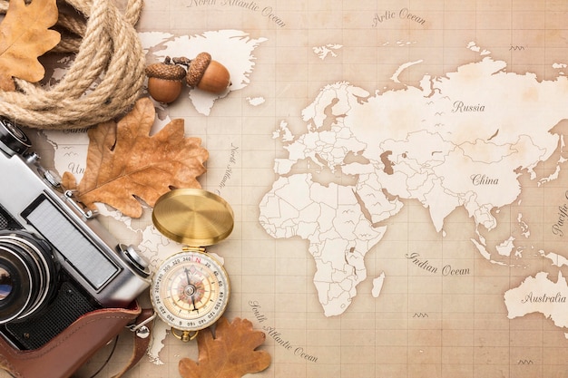 Top view of map with camera and autumn leaves