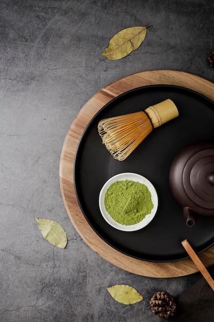 Top view of matcha tea powder and bamboo whisk