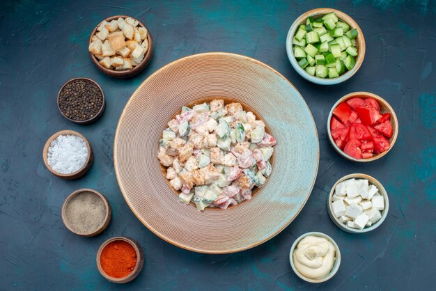 Top view mayyonaise vegetable salad inside plate along with sliced vegetables on the dark desk food meal vegetable