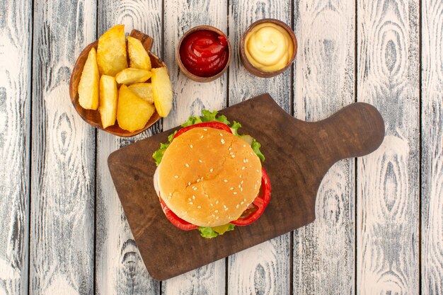 チーズとグリーンサラダポテトとディップのトップビューミートバーガー