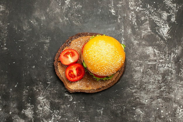 暗い表面のパンファーストフードサンドイッチに野菜とトップビューミートバーガー