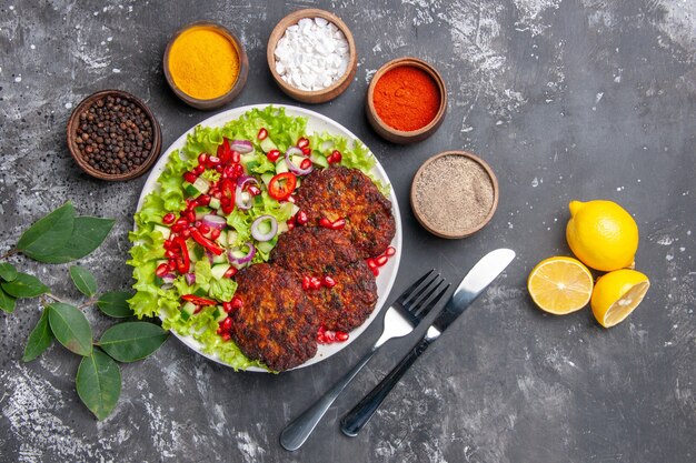 Top view meat cutlets with fresh salad and seasonings