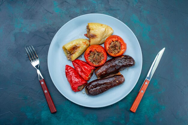 Top view meat inside vegetables dolma inside plate on dark-blue desk food meat dinner health fattening dish