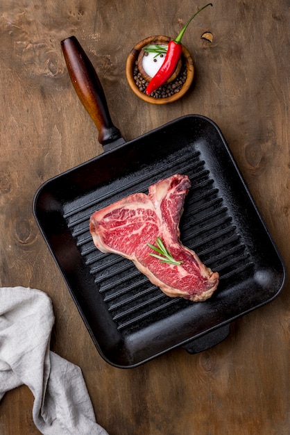 Top view of meat in pan with chili and herbs