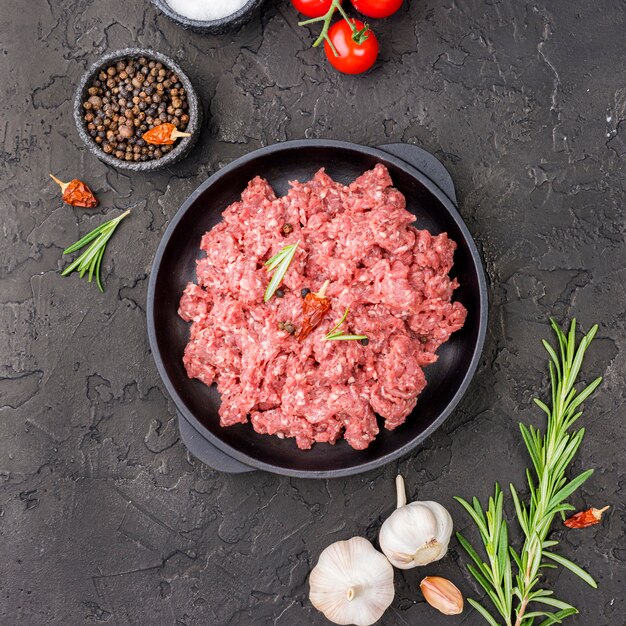 Top view of meat on plate with tomatoes and herbs