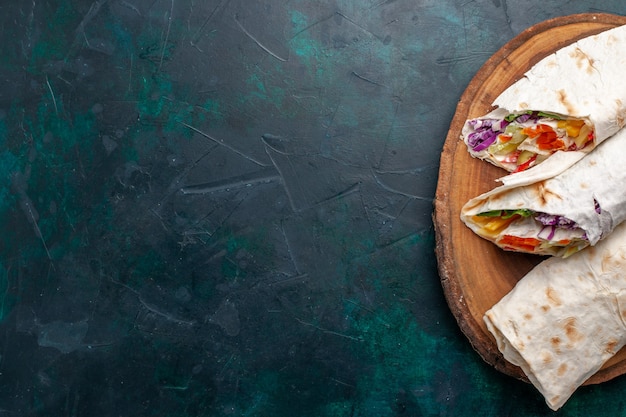 Vista dall'alto sandwich di carne un panino a base di carne alla griglia allo spiedo affettato sulla scrivania blu scuro panino hamburger cibo pasto pranzo carne foto