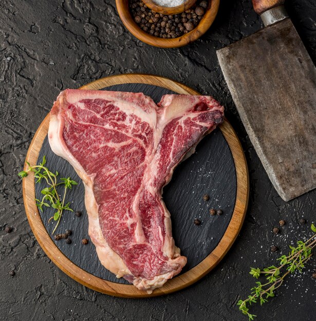 Top view of meat on slate with herbs and spices