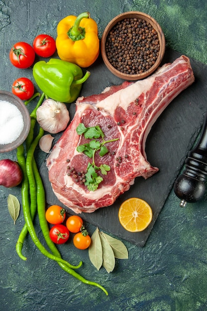 Foto gratuita fetta di carne vista dall'alto con pepe e sale su sfondo blu scuro colore cibo carne cucina animale pollo mucca