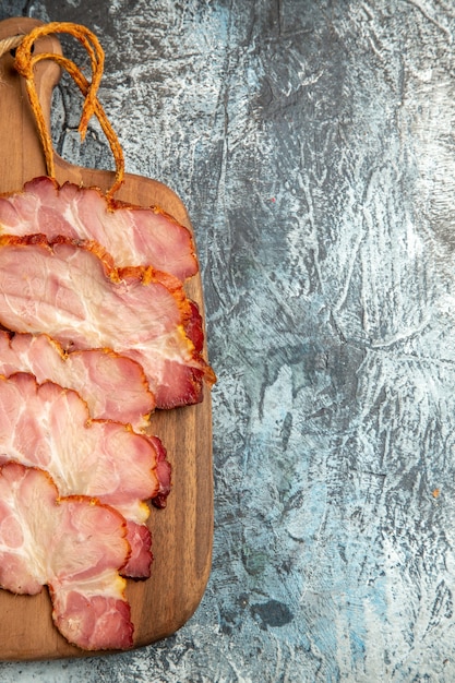 Free photo top view meat slices on cutting board on grey surface