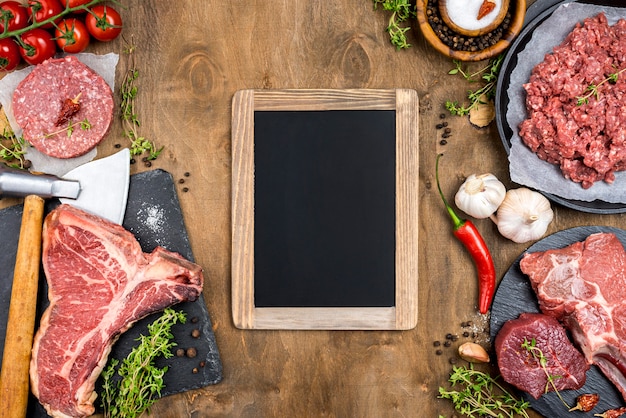 Top view of meat with chili and blackboard