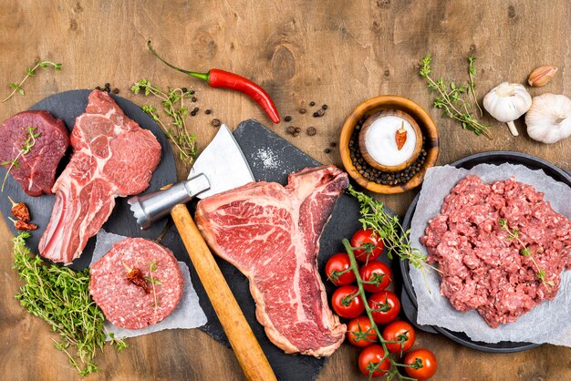 Top view of meat with herbs and tomatoes