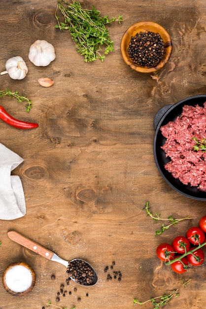 Top view of meat with spices and tomatoes