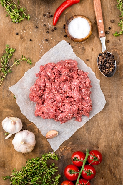 Top view of meat with tomatoes and herbs