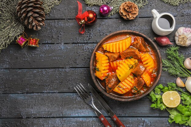 Top view meaty soup with greens and potatoes on a dark floor