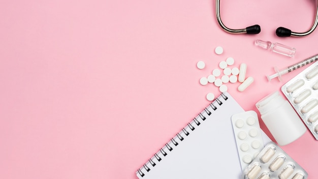 Top view medical desk arrangement on pink background with copy space