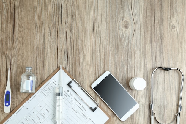 Free photo top view of medical examination report,cellphone,and medical equipments on wooden desk